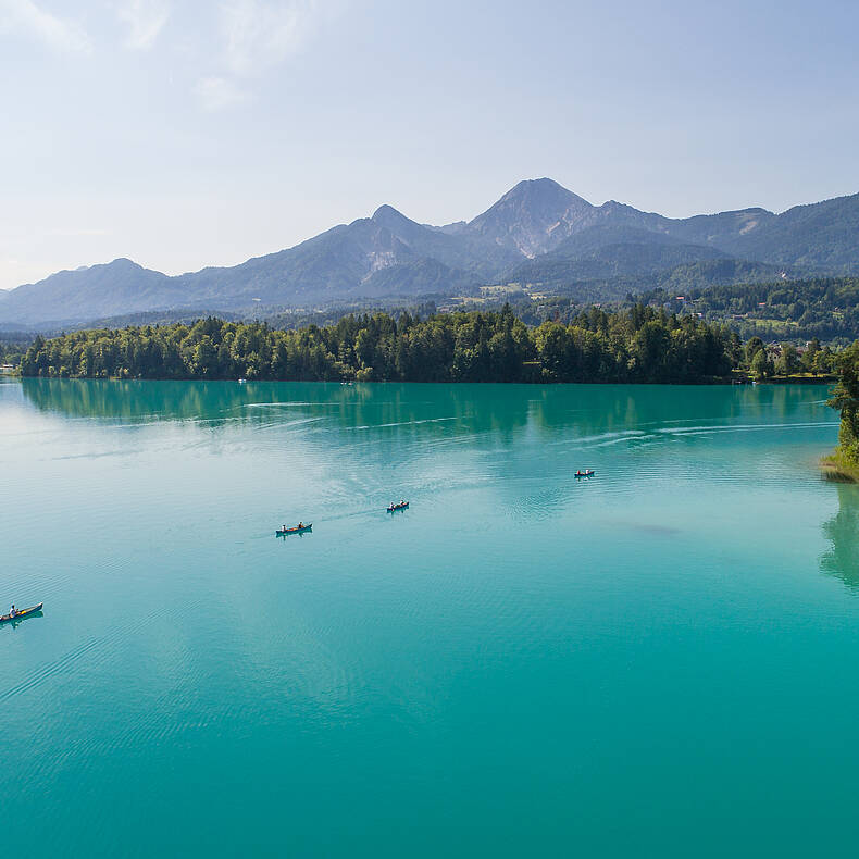 Paddelboote am Faaker See mit Mittagskogel im Hintergrund